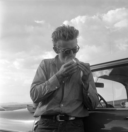 James Dean besides his car during the filming of "Giant"