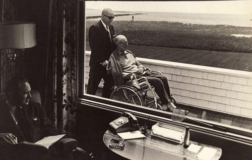 Photo: Jack Kennedy being wheeled past a window of his Hyannis Port home Vintage Gelatin Silver Print #1178