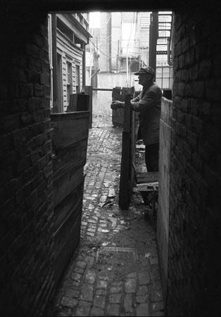 Man in alley, Wilmington, DE, early 1950's<br/>