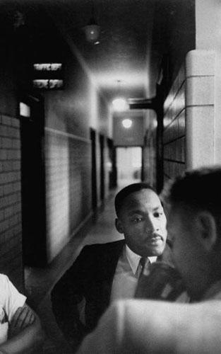 Martin Luther King in hallway as he learns his fine has been paid, Montgomery, Alabama Police Headquarters, 1958 Archival Pigment Print