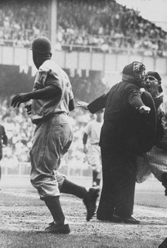 Brooklyn Dodger Jackie Robinson after stealing home base in the 8th inning of the 1st game of the World Series at Yankee Stadium<br/>