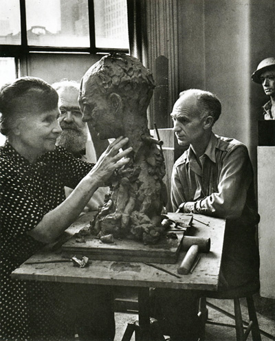In the company of sculptor Jo Davidson and journalist Ernie Pyle, Helen Keller studies with her fingers the surfaces of Davidson's bust of Pyle, 1944