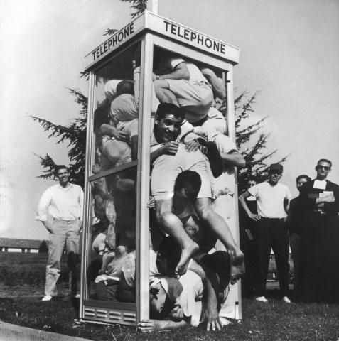 Joe Munroe; Twenty-two exuberant St. Mary's College students folded and stacked inside an on campus phone booth in an attempt to set a record for phone booth cramming, Moraga, California, March 26, 1959<br/>