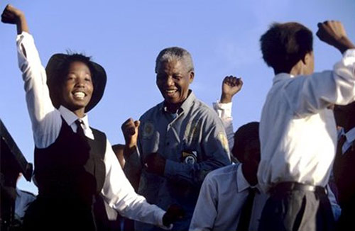 Nelson Mandela dances with schoolchildren at a campaign event, 1994