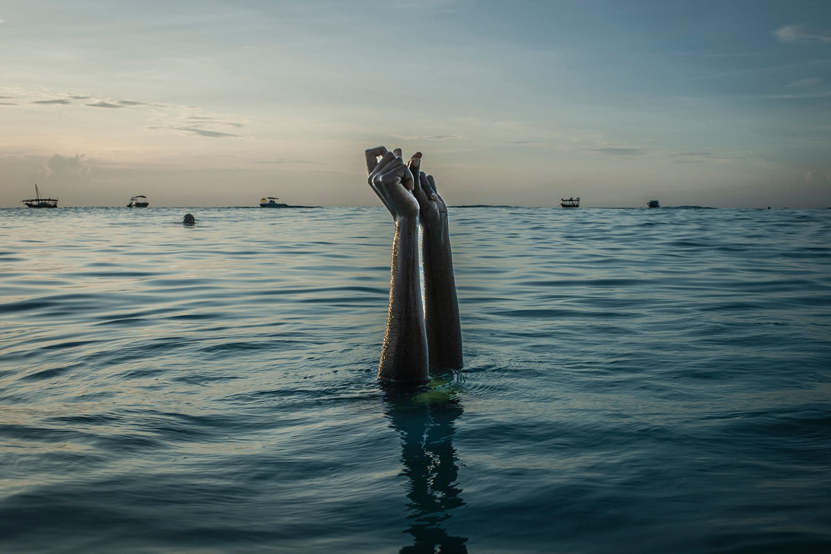 Swim instructor Chema, 17, snaps her fingers as she disappears underwater in Nungwi, Zanzibar, 2016