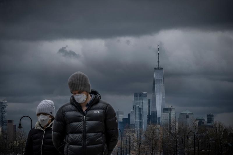 April 18, 2020: With the skyline of lower Manhattan in the background, a couple strolls the boardwalk in Hoboken, NJ during the Covid Pandemic Archival Pigment Print