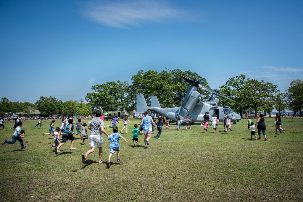 Parents and children run toward a V-22 Osprey, which takes off like a helicopter and flies like a plane, during Fleet Week in New Rochelle, New York, in 2015. 