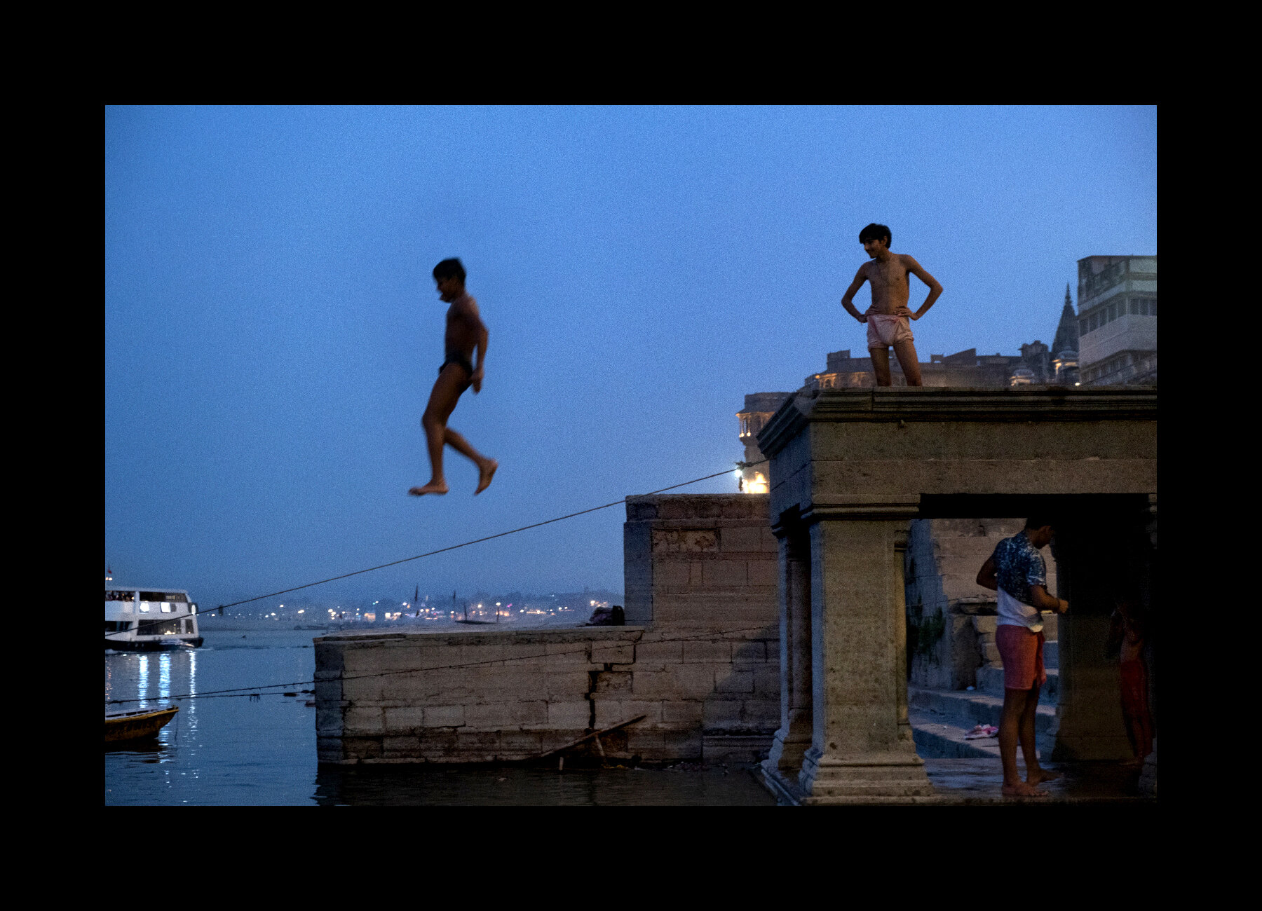 Kids jump off a ghat into the Ganges River in Varanasi, India. 2019