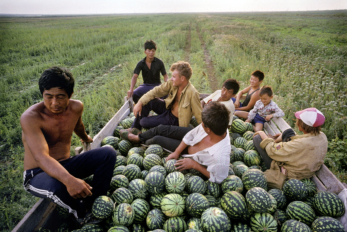 Korean farmers, whose parents immigrated to Crimea in the 1930s, rest with their Russian workers after harvesting watermelons in the town of Krasnoperekopsk. Crimea, Ukraine, 1993