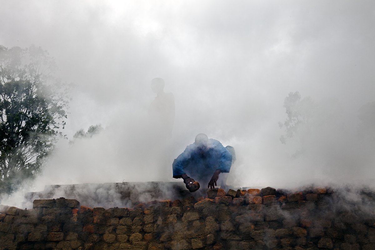 Men work on a brick kiln in Anosibe. This is a very inefficient use of wood, which is the main source of fuel for burning the clay to make the bricks. Madagascar, 2010