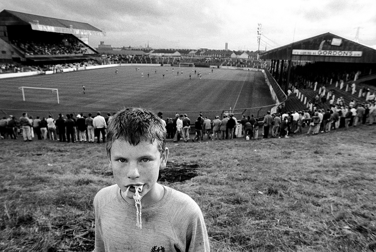 A young Protestant boy at a football game in Linfield Stadium in East Belfast. Northern Ireland, 1989