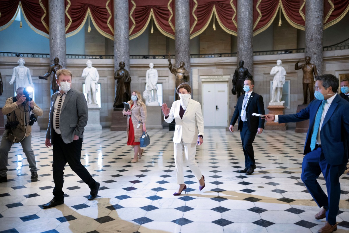 April 23, 2020. Speaker of the House of Representatives Nancy Pelosi is surrounded by press and staff nd media as she walks through the Capitol Rotunda in Washington in the early days of the COVID-19 pandemic