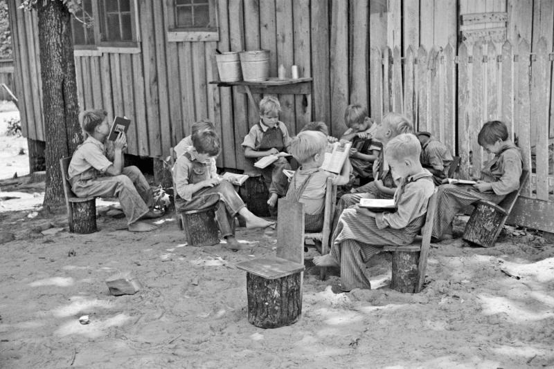 Schoolboys reading books in an outdoor classroom for migrant children at Skyline Farms, near Scottsboro, Alabama June 1936<br/>Please contact Gallery for price