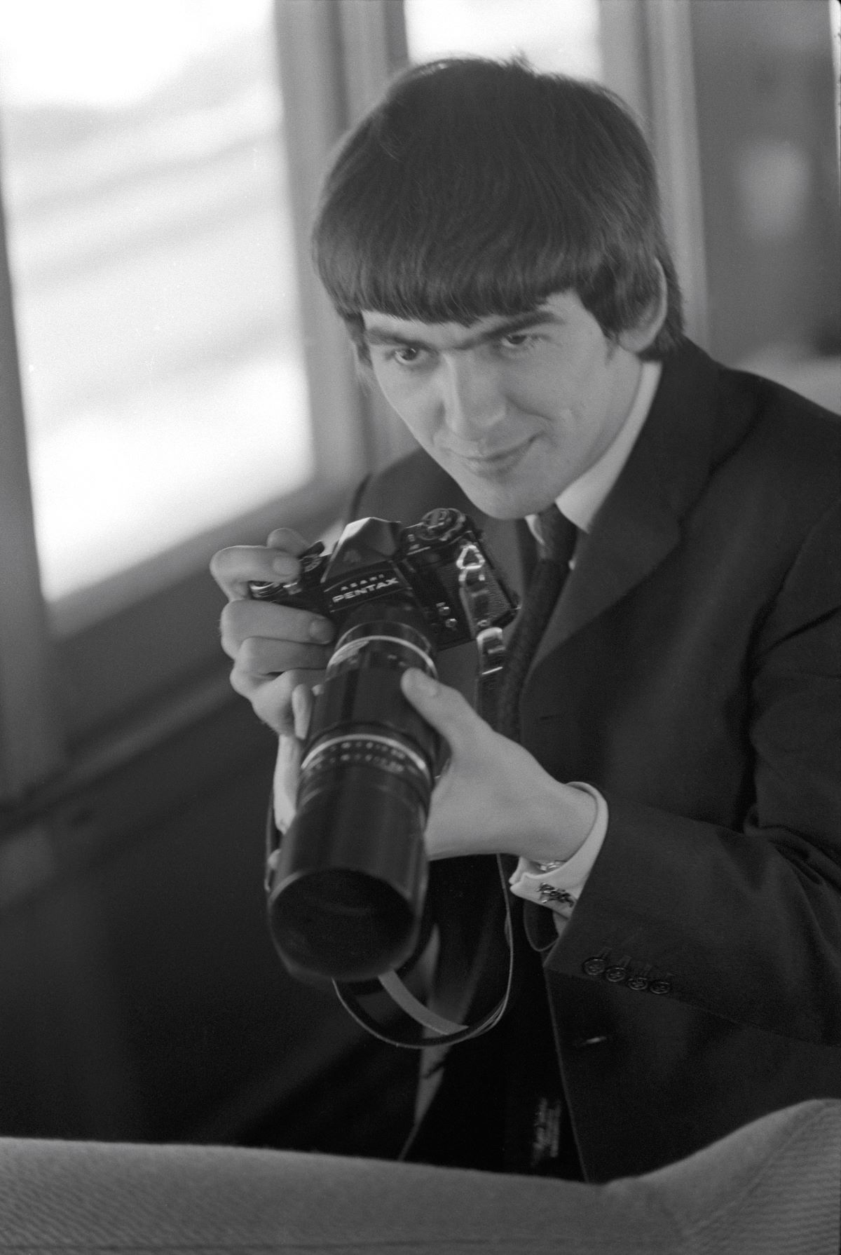 George Harrison with camera, 1964