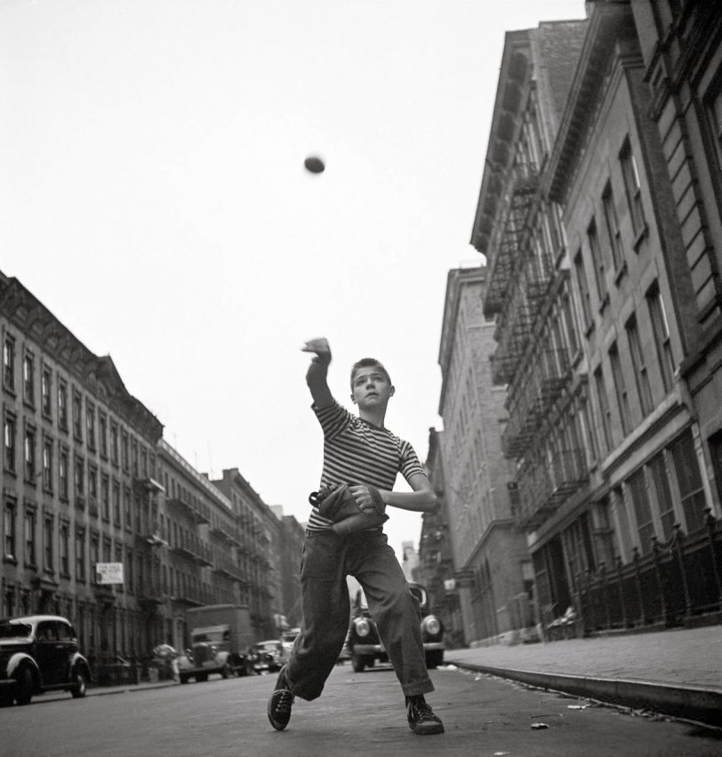 "The Player": Young boy tossing a ball on a city street, New York, 1948