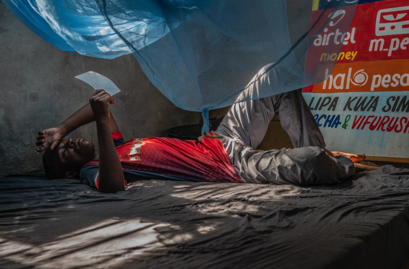 Mchembe under the mosquito net on his bed, Toangoma, Tanzanla, 2024