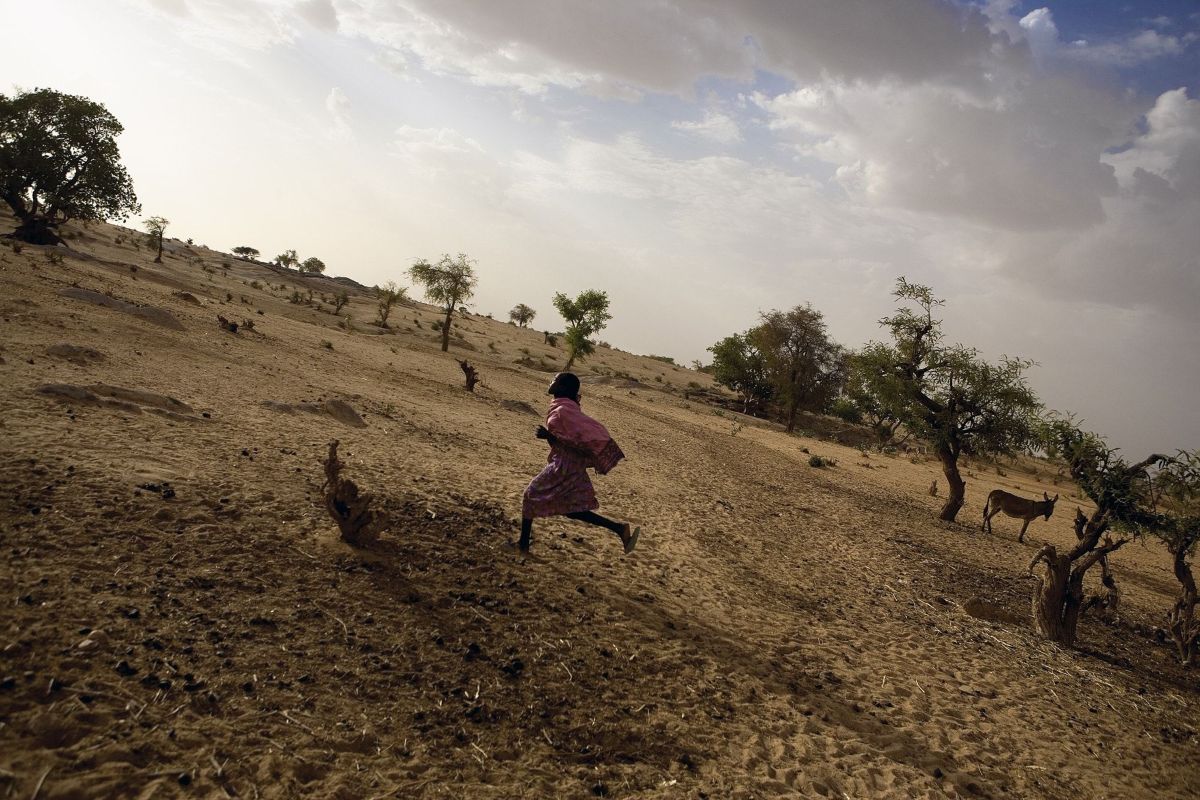 A Darfuri girl runs in a camp for the displaced during the genocide. Darfur, Sudan 2005