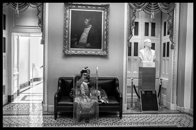 A Trump supporter inside the US Capitol with a police shield stopped for a rest during the  melee, next to a bust of Richard Nixon. Washington, DC January 6, 2021 