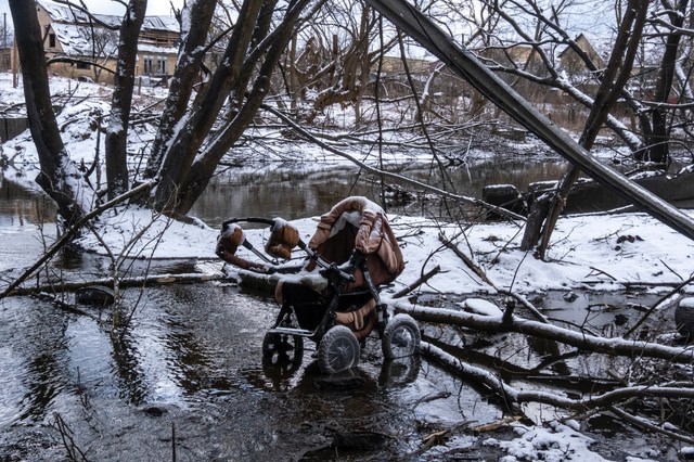 A stroller lays abandoned on the path to safety as people flee a Russian assault. Irpin, Ukraine, 2022