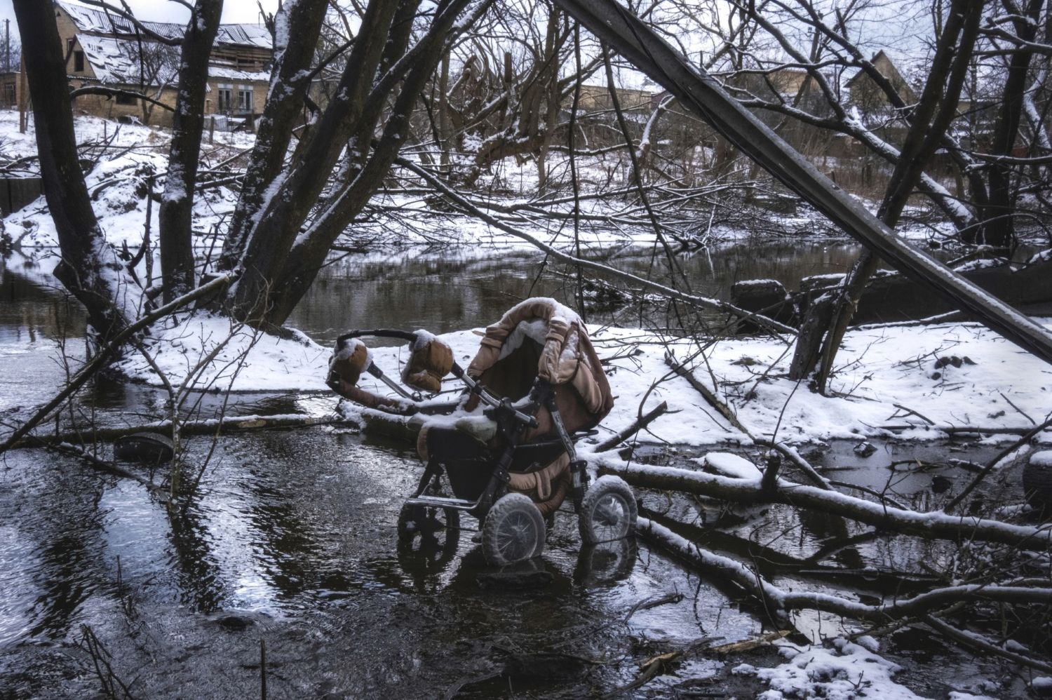 A stroller lays abandoned on the path to safety as people flee a Russian assault. Irpin, Ukraine, 2022