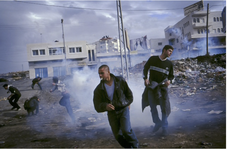 Photo: Palestinians demonstrators fleeing teargas during a clash with Israeli soldiers in Ramallah, the West Bank. 2000. Archival Pigment Print #3076