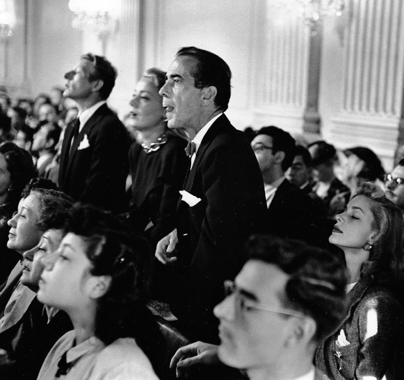 Actors Danny Kaye, June Havoc and Humphrey Bogart, with wife, actress Lauren Bacall sitting beside him, listening intently a hearing regarding communists in the film industry, 1947<br/>