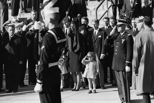 John F. Kennedy Jr. saluting his father's coffin, November 25, 1963 with Ted Kennedy, Jacqueline Kennedy, Rose Kennedy, Peter Lawford, and Robert F. Kennedy in background. Gelatin Silver print