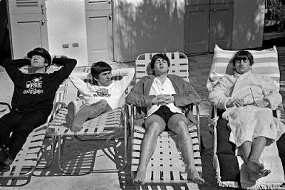 black white photo of the Beatles on lounge chairs poolside in Miami, 1964