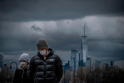 a masked couple strolls the boardwalk in Hoboken, New Jersey, during the COVID-19 pandemic