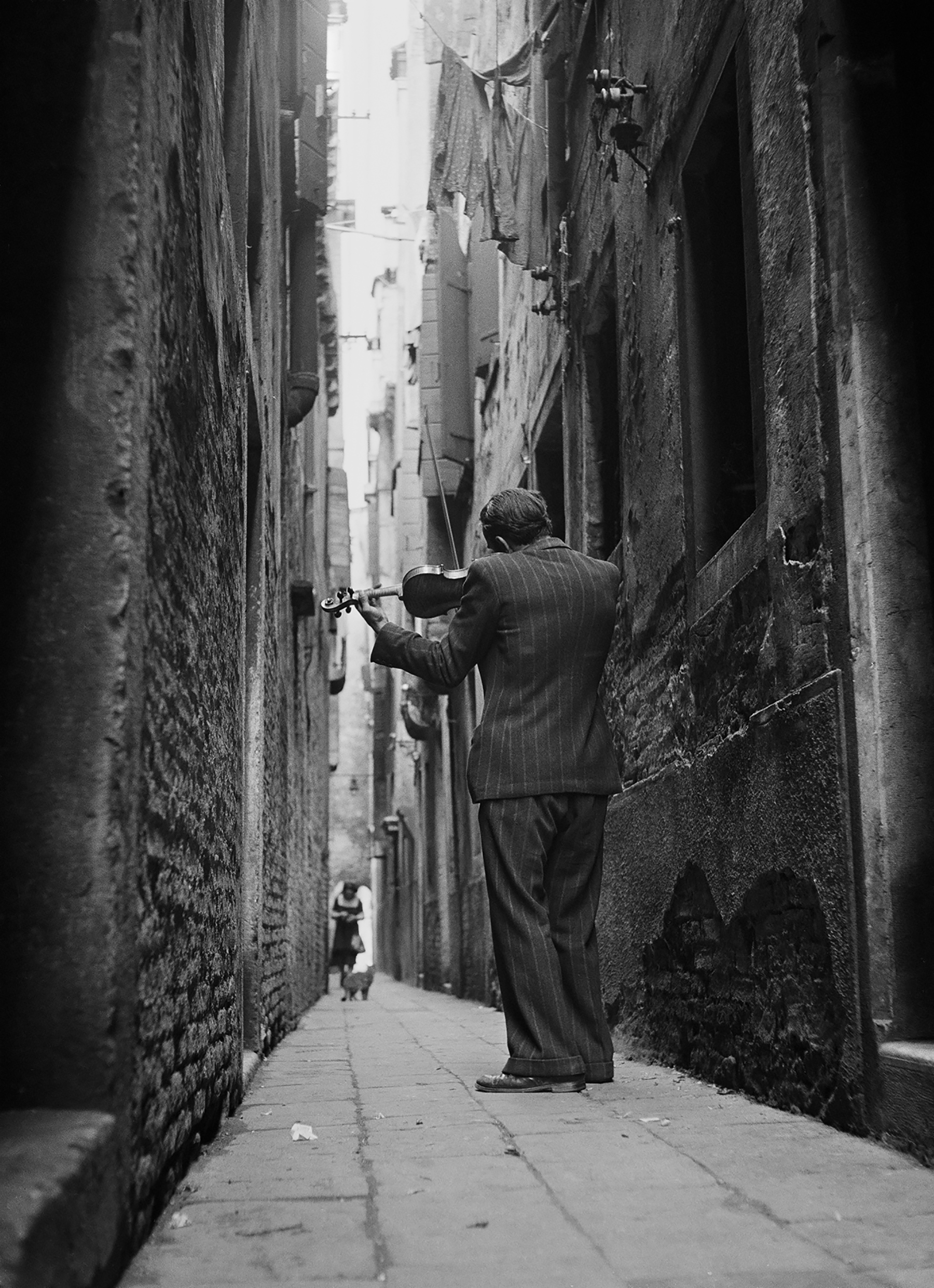 Tony Vaccaro black and white photograph of a violinist on street in in Venice, Italy, 1947